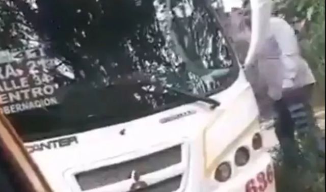 Taxista amenaza con machete a un conductor de bus frente a la mirada de policías